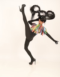 a woman in a costume with a large feather on her head