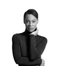 a black woman in a turtle neck top posing for a photo