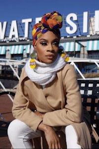 a woman wearing a turban sitting on a bench